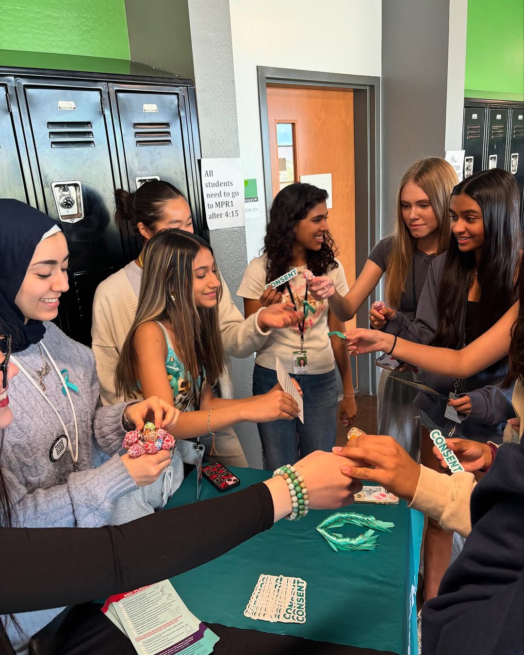 Young BLOOM365 advocates sharing consent resources at a school table